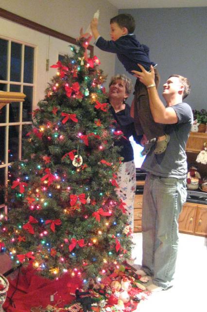 Putting the angel on top of Coco's tree ~ December 1, 2009