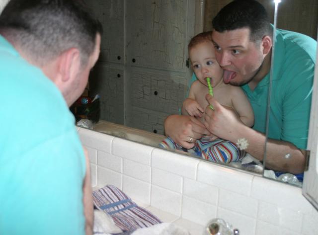 Brushing the teeth. (Daddy has to hold his tongue just right.)